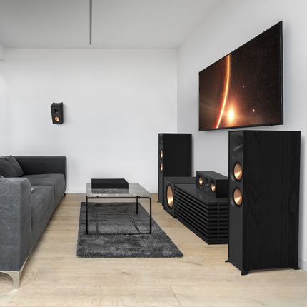 Sistem surround Klipsch complet, cu boxa de centru R-50C sub televizor si o boxa de surround pe peretele lateral