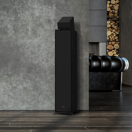 Boxa Klipsch R-600F cu grila montata, intr-un living cu perete de beton, cu un modul Atmos deasupra (vandut separat)