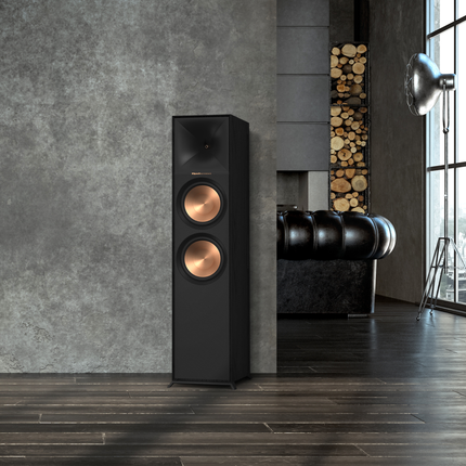 Boxa de podea Klipsch R-800F intr-un living modern, langa un perete de beton