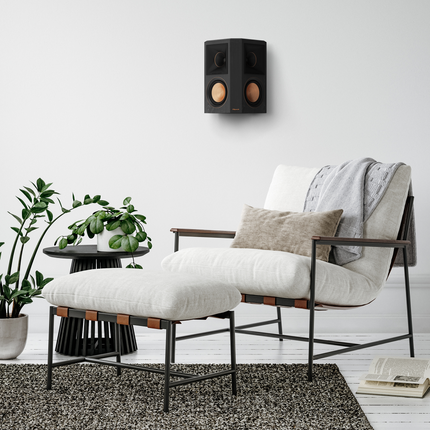 Klipsch RP-502S II Ebony montata pe perete deasupra unui fotoliu, fara grila