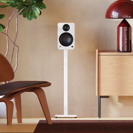 Kanto SP Series stands in Matte White with bookshelf speakers, in a living room