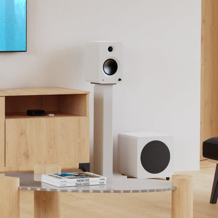 Kanto SX Series stands in Matte White with bookshelf speakers, in a living room
