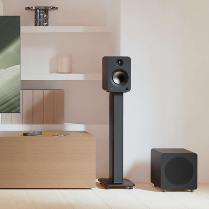Субуфер Kanto Audio SUB8, матово черно, на пода в обзаведена стая, близо до тонколони