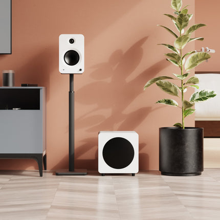 Субуфер Kanto Audio SUB8, матово бяло, на пода в обзаведена стая, близо до тонколони