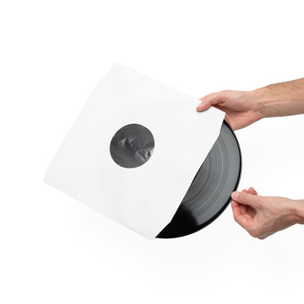 Black vinyl record being slid into a white Kanto Audio TT-IS20 inner sleeve, held in two hands