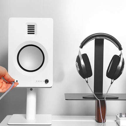 Тонколона Kanto Audio TUK White на бюро, със слушалки, включени в предния изход