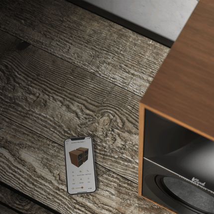Boxa Klipsch The Nines in nuc, langa un telefon cu aplicatia Klipsch Connect deschisa